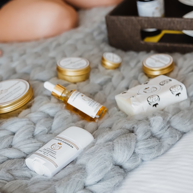 face balm, soup, deodorant and cream on display on bed